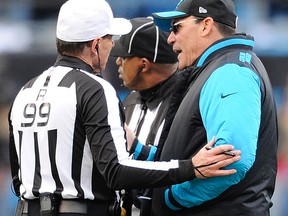 Carolina Panthers head coach Ron Rivera speaks to referee Tony Corrente (99) during the second half of an NFL divisional playoff football game against the Seattle Seahawks, Sunday, Jan. 17, 2016, in Charlotte, N.C. (AP Photo/Mike McCarn)