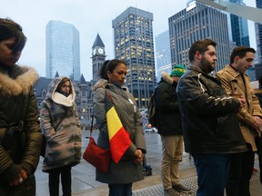 Magali Labe, from Hamori, Belgium, clutches her Belgian flag during a moment of silence at Toronto City Hall to commemorate the victims of the terrorist attacks in Brussels on Tuesday March 22, 2016. (Stan Behal/Toronto Sun)
