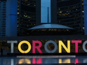 The Toronto sign outside City Hall shines in the Belgian colours in tribute to Brussels victims Tuesday, March 22, 2016. (Stan Behal/Toronto Sun)