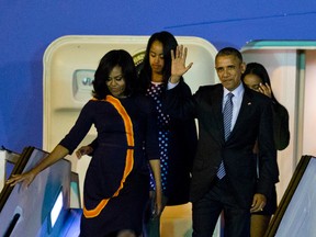 President Barack Obama waves from Air Force One as he arrives accompanied by first lady Michelle and daughters Sasha, behind right, and Malia at the international Buenos Aires airport, Argentina, early Wednesday, March 23, 2016. Obama is on a two day official visit to Argentina. (AP Photo/Natacha Pisarenko)