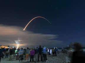 In this photo taken with a long exposure, hundreds line the beach north of the Cocoa Beach Pier in Florida to watch launch of the Orbital ATK’s Cygnus spacecraft off the United Launch Alliance Atlas V rocket at Cape Canaveral Air Force Station, Tuesday, March 22, 2016. Fresh supplies shipped out late Tuesday for the International Space Station, where the shelves finally are getting full after a string of failed deliveries. (Malcolm Denemark/Florida Today via AP)