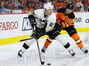 Penguins' Sidney Crosby (left) tries to keep the puck away from Flyers defenceman Mark Streit (right) during third period NHL action in Philadelphia on March 19, 2016. The Penguins will host their state rival Flyers at the NHL Stadium Series game in prime time on Feb. 25, 2017. (Matt Slocum/AP Photo)