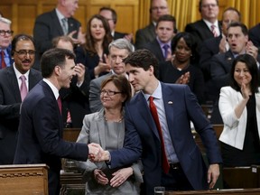 Canada's Prime Minister Justin Trudeau (R) shakes hands with Finance Minister Bill Morneau after delivering the federal budget in the House of Commons on Parliament Hill in Ottawa, Canada March 22, 2016. REUTERS/Chris Wattie