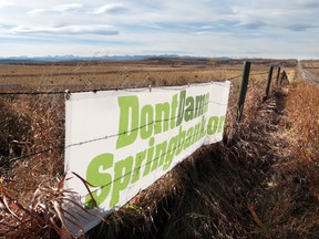 Signs supporting the DontDamnSpringbank.org movement are posted on fences along Springbank Road on October 17, 2014. Colleen De Neve/Postmedia