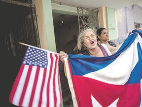 A Cuban woman celebrates the visit by U.S. President Barack Obama, while holding a Cuban and an American flag in Havana Tuesday. Up to three million U.S. visitors are expected now that the U.S. ban on travel to Cuba has been lifted. (Ramon Espinosa/AP Photo)