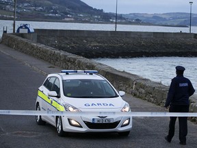 Irish police guard the entrance to  Buncrana Pier which leads into Lough Swilly in Co Donegal Ireland Monday March 21, 2016.   (PA via AP)