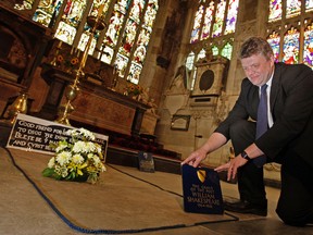 In this Sept. 21, 2009 file photo, Head Verger Jon Ormrod tends to the grave of William Shakespeare in the Chancel of Holy Trinity Church in Stratford-upon-Avon, England. Archeologists who scanned the grave of William Shakespeare say they have made a startling discovery: His skull appears to be missing. (AP Photo/Kirsty Wigglesworth, file)