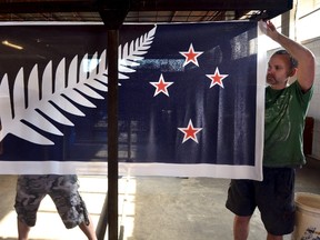 Factory workers Garth Price (R) and Andrew Smith hold up a potential national flag of New Zealand at a factory in Auckland, New Zealand, in this November 24, 2015 file photo. But New Zealanders voted on March 24, 2016 against the new design and in favour of retaining the country's current flag.  REUTERS/Rafael Ben-Ari/Files