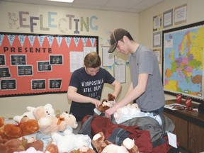 Noah Steele and Garyn Topola pack teddy bears to distribute to children at a hospital during their mission trip to Guatemala this week. Nine students from Living Waters Christian Academy are taking part in the trip. - Photo by Marcia Love