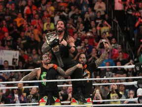 WWE superstar Roman Reigns sits on the shoulders of his Samoan cousins Jimmy and Jey Uso after winning the WWE World Heavyweight Championship in Philadelphia. Reigns, a former CFL player with the Edmonton Eskimos, faces Triple H for that title at WrestleMania 32 in Dallas on April 3. (George Tahinos/SLAM! Wrestling)