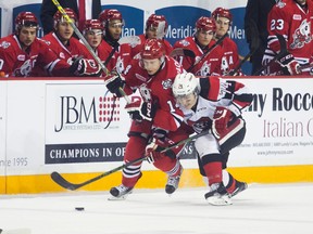 Christopher Paquette of the Niagara IceDogs and Adam Craievich of the Ottawa 67s fight for the puck during OHL playoff action at the Meridian Centre in St. Catharines, Ont., on Thursday, March 24, 2016. (Julie Jocsak/Postmedia Network)