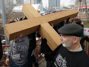 Hundreds of people walked for two kilometers through downtown Edmonton carrying a wooden cross at Edmonton's 36th Annual Good Friday Outdoor Way of the Cross walk on Friday March 25, 2016.