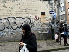A woman passes close to the house where Salah Abdeslam, the most-wanted fugitive from November's Paris attacks, was arrested after a shootout with police on Friday in the Brussels district of Molenbeek, March 19, 2016. REUTERS/Eric Vidal