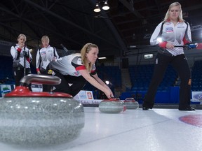 Canada skip Chelsea Carey takes a shot as teammates second, Jocelyn Peterman, left to right, third, Amy Nixon and lead, Laine Peters look on during a practice session at the women's world curling championship in Swift Current, Sask., on Friday, March 25, 2016. (Jonathan Hayward/THE CANADIAN PRESS)