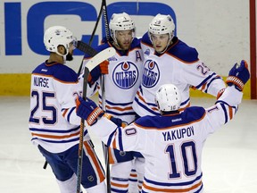 Edmonton Oilers forward Taylor Hall is hugged by teammates after scoring against the San Jose Sharks on March 24 (Marcio Jose Sanchez/AP)