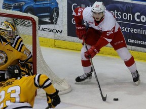 Jack Kopacka of the Sault Ste. Marie Greyhounds surveys where to distribute the puck near Sarnia Sting goalie Charlie Graham and defenceman Zach Core during Game 1 of the Ontario Hockey League Western Conference quarter-final at the Sarnia Sports and Entertainment Centre on Friday, March 25, 2016 in Sarnia, Ont. (Terry Bridge, Sarnia Observer)