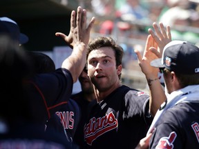 Tyler Naquin celebrates in the Indians dugout after hitting his third homer of the spring on Thursday against the Reds. (Darron Cummings, AP)