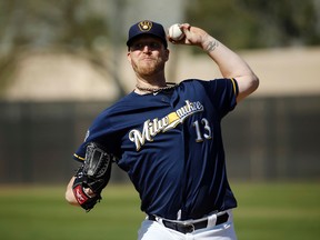 Milwaukee Brewers' Will Smith throws during a spring training baseball workout in Phoenix. The Milwaukee Brewers will start the season without Smith, who tore a ligament in his right knee while taking his spikes off after a game, Saturday, March 26, 2016. (AP Photo/Morry Gash, File)
