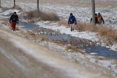 Volunteers search through a ditch beside a farmers' field hoping to find 2 year old Chase Martens near Austin, Man., on Friday, March 25, 2016. An overnight snowfall is making the search, a race against time in locating the missing bow, even more difficult. THE CANADIAN PRESS/John Woods