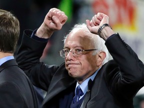 Democratic U.S. presidential candidate Sen. Bernie Sanders pumps his fists as he leaves the field after speaking at a rally Friday, March 25, 2016, in Seattle. (AP Photo/Elaine Thompson)