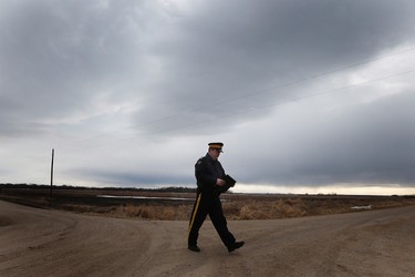 RCMP Sgt. Bert Paquet walks across a country road to update media on the discovery of two-year-old Chase Martens' body in a creek close to his home just north of Austin, Manitoba on Saturday, March 26, 2016. Martens went missing from his family home Tuesday evening. THE CANADIAN PRESS/John Woods