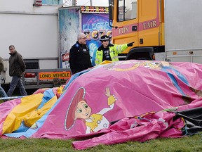 Police and forensic officers attend the scene Sunday, March 27, 2016, where a seven-year old girl died after she was blown by the wind about 150 metres on a bouncy castle on Saturday.  (Stefan Rousseau / PA via AP)