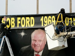 Workers replace a roadside billboard with a Rob Ford memorial on March 22. (ANDREW COLLINS PHOTO)
