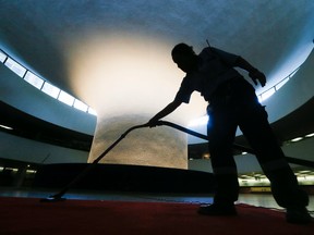 Nelia Bettencourt vacuums the red carpet in the Toronto City Hall rotunda where former Toronto mayor Rob Ford's body will lay in repose. (STAN BEHAL, Toronto Sun)