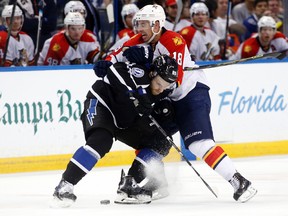 Tampa Bay Lightning defenseman Nikita Nesterov (89), of Russia, collides with Florida Panthers right wing Reilly Smith (18) while battling for the puck during the third period of an NHL hockey game Saturday, March 26, 2016, in Tampa, Fla. (AP Photo/Brian Blanco)