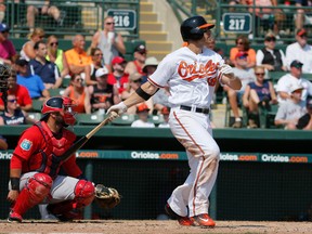 Baltimore Orioles' Chris Davis follows through on a solo home run swing off a pitch from Boston Red Sox's Roenis Elias as catcher Sandy Leon watches in the sixth inning of a spring training baseball game, Saturday, March 26, 2016, in Sarasota, Fla. (AP Photo/Tony Gutierrez)