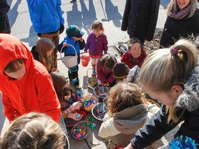After finding the more than 300 hidden Easter eggs all along Reden Street, the kids help open the eggs and share the discovered treats from the annual neighbourhood Easter egg hunt in Kingston, Ont. on Sunday March 27, 2016. Julia McKay/The Whig-Standard/Postmedia Network