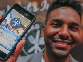 Richard Green, of Second Waiter Inc., holds up a phone with the Second Waiter app that tells you what is in restaurant food to avoid allergies. (Dave Thomas/Toronto Sun)
