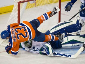 Edmonton Oilers Matt Hendricks  collides with Vancouver Canucks goaltender Jacob Markstrom after scoring during third period NHL action on March 18, 2016 in Edmonton