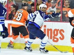 Winnipeg Jets defenseman Dustin Byfuglien (33) reaches for puck against the Philadelphia Flyers during the second period at Wells Fargo Center.