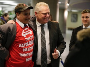 Doug Ford poses for a picture with a cab driver as his brother Rob Ford lies in repose at City Hall on Monday, March 28, 2016. (Craig Robertson/Toronto Sun)