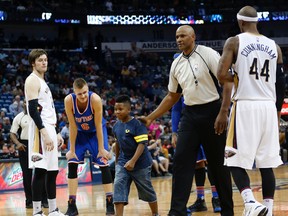 A young boy is sent back to the stands by the referee after he ran onto the court in the second half of an NBA game between the Pelicans and the Knicks in New Orleans on Monday, March 28, 2016. (Gerald Herbert/AP Photo)