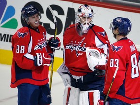 Capitals goalie Braden Holtby (centre) celebrates with defenceman Nate Schmidt (88) and centre Jay Beagle (83) after defeating the Blue Jackets in Washington on Monday, March 28, 2016. (Alex Brandon/AP Photo)