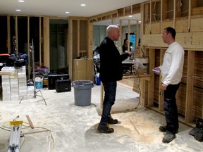 Crew leader Randy Blain consults with Justin. Elevating a house comes with its own set of problems.