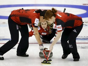 Jennifer Jones (centre) instructs her sweepers Dawn McEwen (right) and Jill Officer during their semi-final curling match against Russia at the World Women's Curling Championships in Sapporo last year. (REUTERS/Thomas Peter file photo)