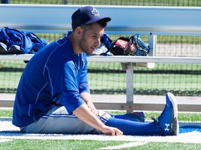 Toronto Blue Jays pitcher Marco Estrada sits on the sidelines stretching during spring training in Dunedin, Fla. on Sunday. February 28, 2016. (THE CANADIAN PRESS/Frank Gunn)