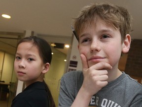 Maria-Alexandra Gagnon and Donald Champ wait for a meeting to start at the Ottawa-Carleton District School Board in Ottawa on Tuesday. The two Grade 5 students spoke at the meeting. They want to keep the English program at the school.