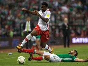 Canada's Cyle Larin fights for the ball with Mexico's Nestor Araujo during a World Cup qualifying soccer match in Mexico City on March  29, 2016. (AP Photo/Christian Palma)