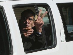EgyptAir plane hijacking suspect Seif Eldin Mustafa flashes the victory sign as he leaves a court in a police car after a remand hearing as authorities investigate him on charges including hijacking, illegal possession of explosives and abduction in the Cypriot coastal town of Larnaca on March 30, 2016. (AP Photo/Petros Karadjias)