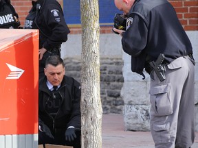 Tim Miller/The Intelligencer
Ron Gignac, deputy chief of police for the Belleville Police Service, checks the contents of a suspicious package left in front of city hall on Wednesday.