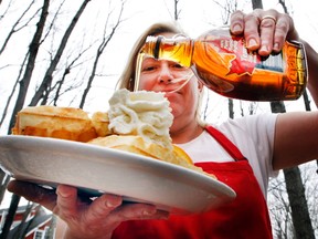 Moira Wilkie, manager at Temple's Sugarbush, soaks a plate of waffles with some of their maple syrup Wednesday March 30, 2016. Warm days and cool nights have contributed to a bumper crop this year.