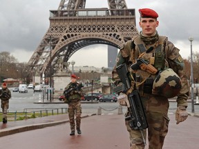 French army paratroopers patrol near the Eiffel tower in Paris. France has decided to deploy 1,600 additional police officers to bolster security at its borders and on public transport following the deadly blasts in Brussels.  (REUTERS/Philippe Wojazer)