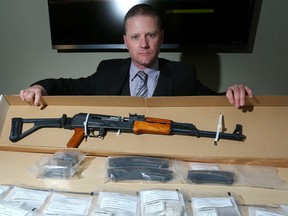 Staff Sgt. Keith Hurley poses with an AK-47 assault rifle that was seized from a Calgary home along with $57,000 worth of cocaine, methamphetamine and heroin during a media availability in Calgary, Ab., on Wednesday March 30, 2016. Leah Hennel/Postmedia