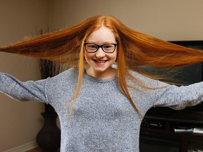 Calista Verkerk shows off her long ginger tresses in her home in Kingston, Ont. on Wednesday March 30, 2016. The 12-year old has been raising money and awareness in preparation to get her hair cut on Friday and donating it to Angel Hair For Kids to make hairpieces for kids in need. Julia McKay/The Whig-Standard/Postmedia Network