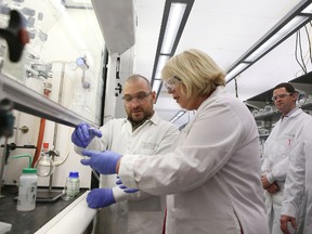 Product development scientist Brandon Djukic of GreenCentre Canada hands a flask to Ontario Deputy Premier Deb Matthews during her tour of the chemical lab on Tuesday, March 30, 2016. 
Elliot Ferguson/The Whig-Standard/Postmedia Network