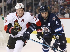 Ottawa Senators winger Chris Neil battles Winnipeg Jets defeceman Mark Stuart on March 30. (USA Today Sports)